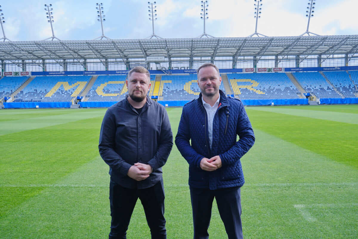 Napis MOTOR na stadionie Arena Lublin już gotowy. Brakuje jeszcze białego koloru. „Akcent na pewno się pojawi” 1 Rzecznik Motoru Lublin Bartłomiej Adamiak i wiceprezes MOSiRu Krzysztof Komorski na tle napisu MOTOR na Arenie Lublin
