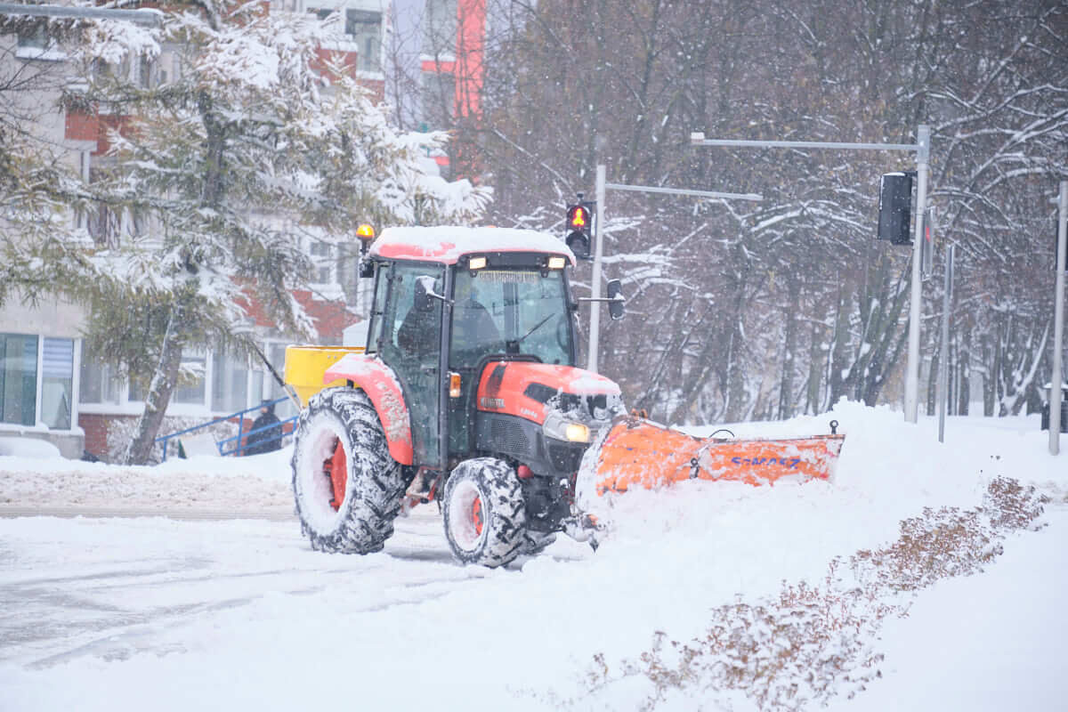 Sypnęło śniegiem w Lublinie. Główne ulice przejezdne, trudna sytuacja na osiedlowych uliczkach 1 Opłużony traktor odśnieżający chodnik