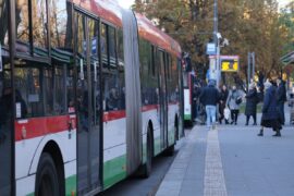 pasazerowie wsiadajacy do autobusu na przystanku