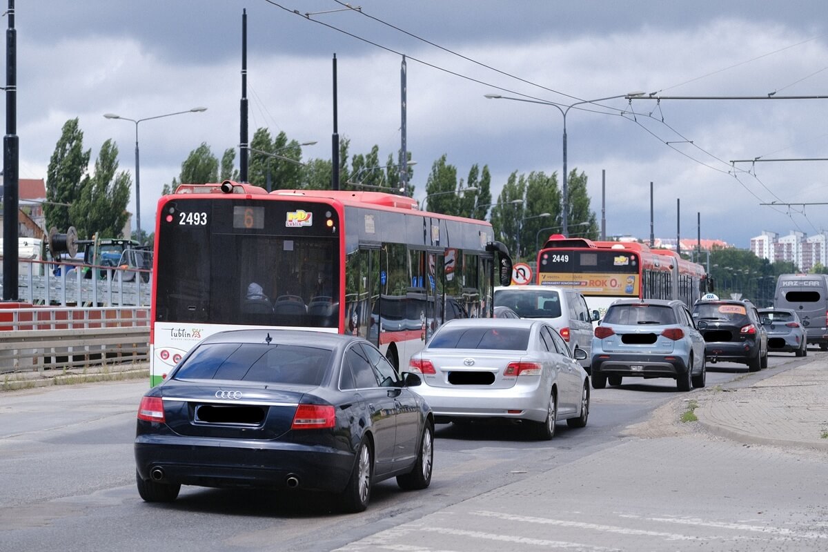 Auta i pojazdy komunikacji miejskiej przed skrzyżowaniem al. Unii Lubelskiej z ul. Zamojską